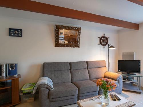 a living room with a couch and a tv at Holiday Home Ty Pendruc by Interhome in Trégunc