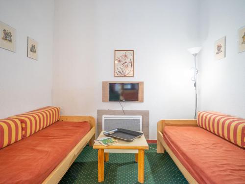 Cette chambre comprend deux bancs et une table avec une télévision. dans l'établissement Apartment La Balme-1 by Interhome, à Chamonix-Mont-Blanc