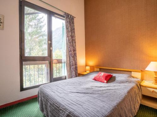 une chambre avec un lit avec un oreiller rouge dessus dans l'établissement Apartment La Balme-1 by Interhome, à Chamonix-Mont-Blanc