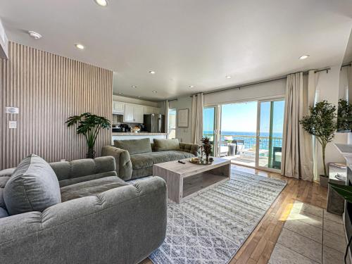 a living room with a couch and a table and a kitchen at Cozy House With Ocean View - PCH-R-MA in Malibu