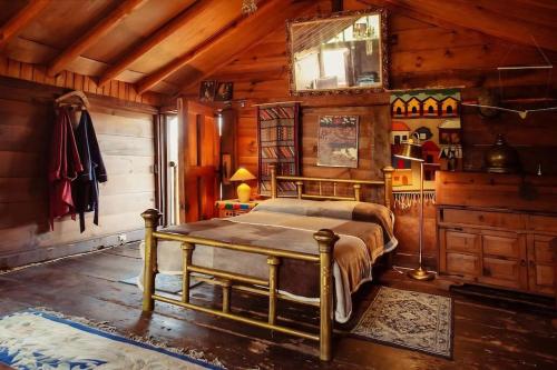 1 dormitorio con 1 cama en una habitación de madera en La Troje Cabañas en Tepoztlán