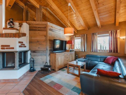 a living room with a leather couch and a tv at Chalet Hochkrimml 2 by Interhome in Krimml