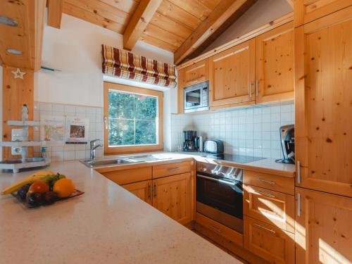 a kitchen with wooden cabinets and a sink and a window at Chalet Hochkrimml 2 by Interhome in Krimml