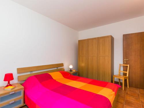 a bedroom with a colorful bed and a wooden cabinet at Holiday Home Podere gli Olivi by Interhome in Nibbiaia