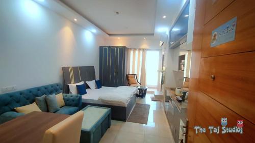 una camera d'albergo con letto e divano di LIMITLESSTRIP com- Best Stay at Central Noida #With Balcony #Free Parking #Wifi #Independent Apartment #Fully Equipped Kitchen a Noida