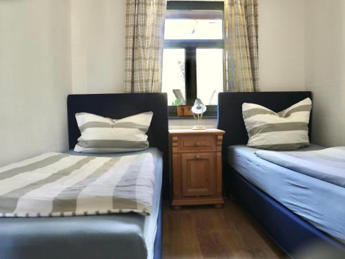 1 Schlafzimmer mit 2 Betten und einem Tisch mit einem Fenster in der Unterkunft Apartment Gästehaus Alte Schule-1 by Interhome in Dargun