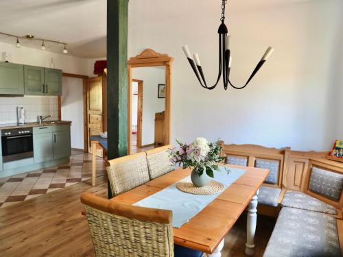 a dining room with a table with a vase of flowers at Apartment Rügen by Interhome in Dargun