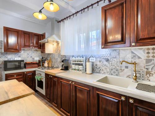 a large kitchen with wooden cabinets and a sink at Holiday Home Centar by Interhome in Umag