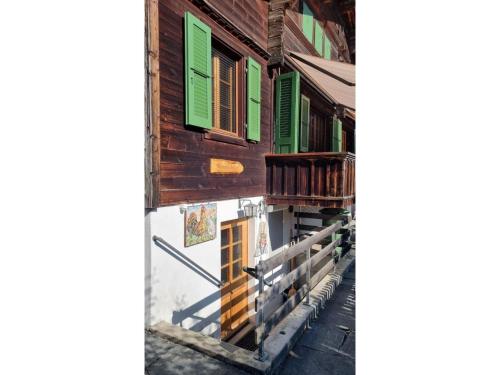 ツヴァイジンメンにあるApartment Bachhüsi by Interhomeの緑の窓の並ぶ家