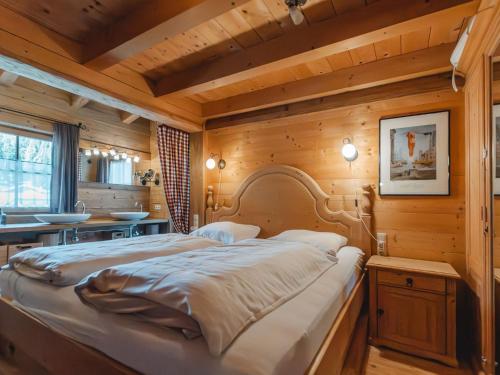 a large bed in a room with wooden walls at Chalet Königsleiten 3 by Interhome in Königsleiten