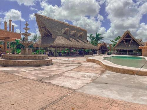 a resort with a swimming pool and a fountain at Hacienda Ixtlan Cozumel in Cozumel