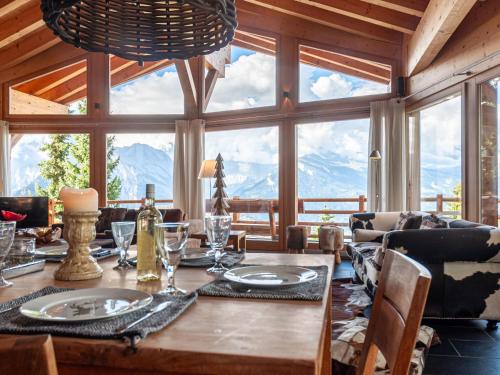 ein Esszimmer mit einem Tisch und einem großen Fenster in der Unterkunft Chalet Sebas by Interhome in Nendaz