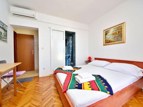 a bedroom with a bed and a desk and a table at Apartment Jelka-3 by Interhome in Trstenik