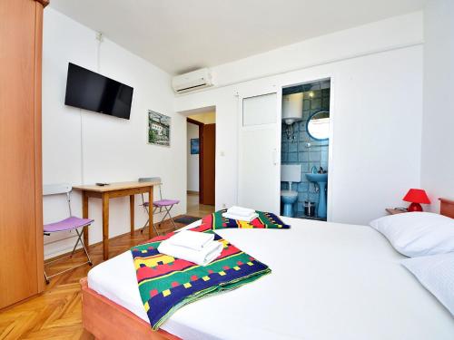 a bedroom with two beds and a table and a television at Apartment Jelka-3 by Interhome in Trstenik