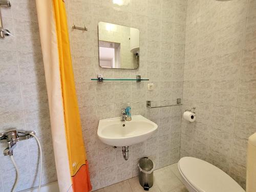 a bathroom with a sink and a toilet and a mirror at Apartment Jelka-3 by Interhome in Trstenik
