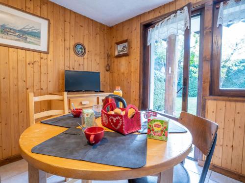 une salle à manger en bois avec une table et une corbeille de fruits. dans l'établissement Apartment Clos des Outannes-1 by Interhome, à Chamonix-Mont-Blanc