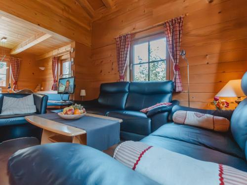 a living room with blue leather furniture in a cabin at Chalet Königsleiten 1 by Interhome in Königsleiten