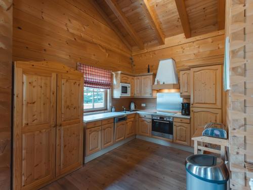 a kitchen with wooden cabinets and a stove at Chalet Königsleiten 1 by Interhome in Königsleiten