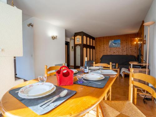 a wooden table with plates and silverware on it at Apartment Le Prarion by Interhome in Les Houches
