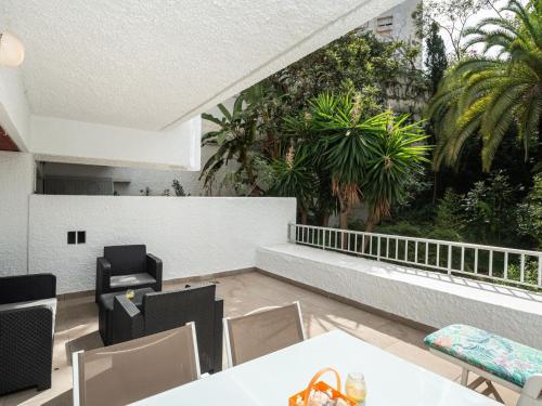 a balcony with tables and chairs and palm trees at Apartment Jardines Del Mar by Interhome in Marbella