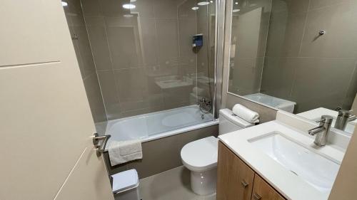 La salle de bains est pourvue de toilettes, d'un lavabo et d'une douche. dans l'établissement Depto central, parking, moderno, à Chillán