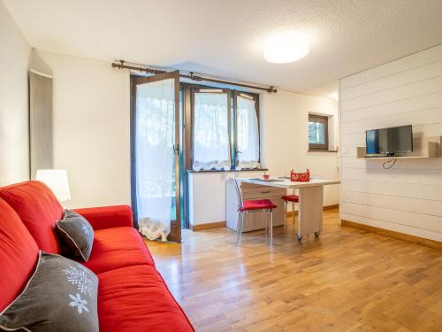 - un salon avec un canapé rouge et un bureau dans l'établissement Apartment Champraz-17 by Interhome, à Chamonix-Mont-Blanc