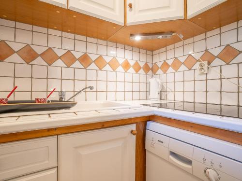 une cuisine avec des armoires blanches et un évier dans l'établissement Apartment Champraz-17 by Interhome, à Chamonix-Mont-Blanc