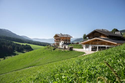 una casa en una colina junto a un campo verde en Unterkantiolerhof, en Funes