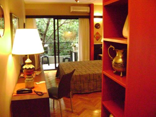 a room with a desk and a bedroom with a bed at Studio Rojo Belgrano in Buenos Aires