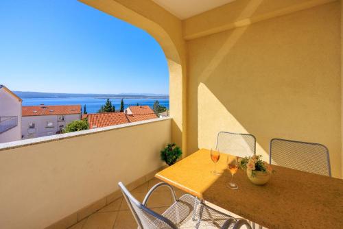una mesa y sillas en un balcón con vistas al océano en Apartments Petak, en Dramalj