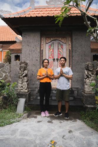 two people standing in front of a house at Sweet Orange Pondok in Ubud