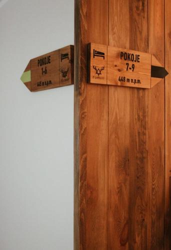 a wooden door with two signs on it at FORREST in Polanica-Zdrój
