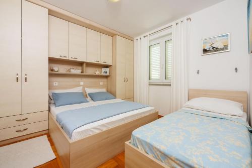 - une chambre avec deux lits et une armoire dans l'établissement Apartments Petak Novi, à Dramalj