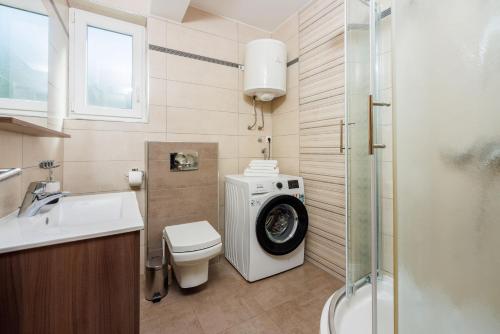 La salle de bains est pourvue d'un lave-linge et de toilettes. dans l'établissement Apartments Petak Novi, à Dramalj