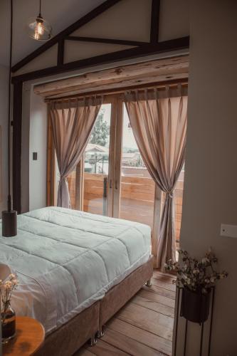 a bedroom with a large bed and a large window at Casa Faustina - Templo de la Luna in Cusco