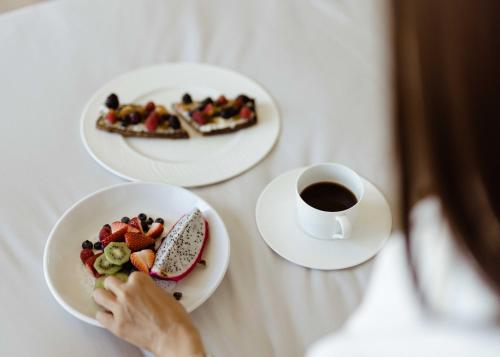 a woman sitting at a table with plates of food and a cup of coffee at W Scottsdale in Scottsdale