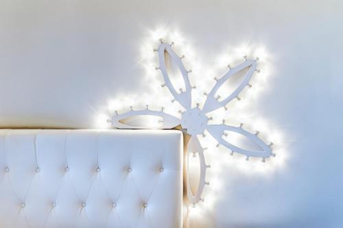 a white wall with a flower shaped clock on it at Vittoria Luxury House in Lecce