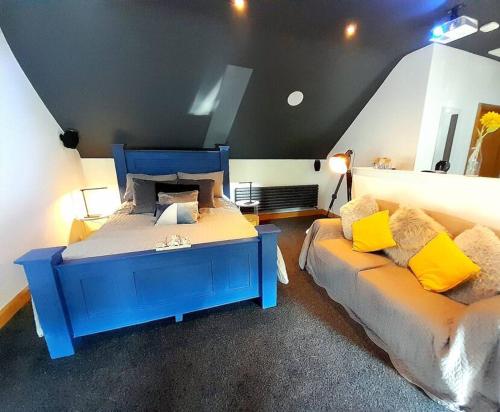 1 dormitorio con 1 cama azul y 1 sofá en Serenity Lodge, 