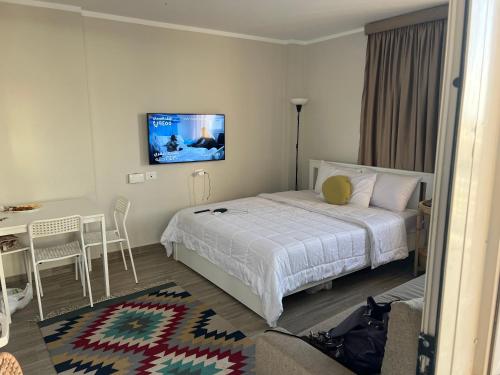 a bedroom with a bed and a table and a tv at Luxury stay roof top in 6th Of October