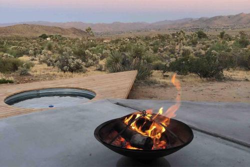 a fire pit on a table with a view of the desert at Perched on Paradise House in Yucca Valley