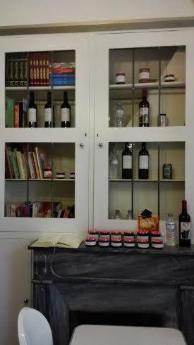 a cabinet with glass doors with bottles of wine at Bed & Breakfast Bells Oficis in Girona