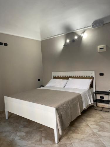 um quarto branco com uma cama branca com luzes na parede em ROMA PARADISO GUEST HOUSE em Roma