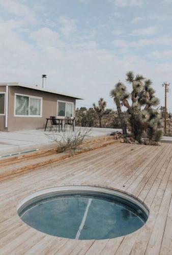 a wooden deck with a pool in the middle of a house at Perched on Paradise House in Yucca Valley