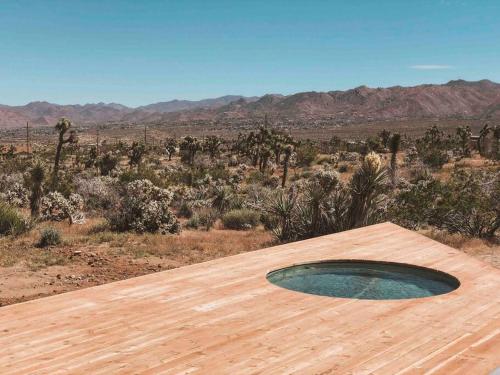a wooden deck with a pool in the middle of the desert at Perched on Paradise House in Yucca Valley