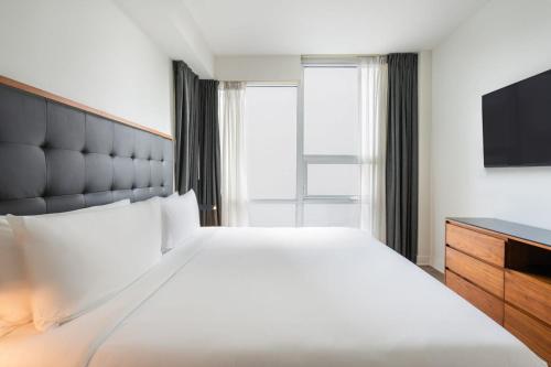 a hotel room with a bed and a television at Level Downtown LA South Olive in Los Angeles