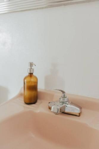 a soap bottle sitting on a bathroom sink at Perched on Paradise House in Yucca Valley