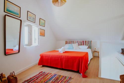 una camera da letto con un letto con una coperta rossa di Casa do Meio a Cela