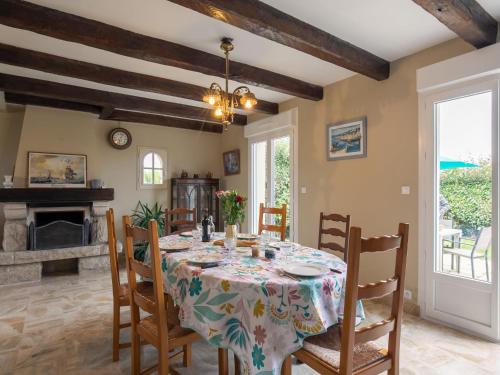 une salle à manger avec une table et des chaises et une cheminée dans l'établissement Holiday Home An Theven by Interhome, à Cléder