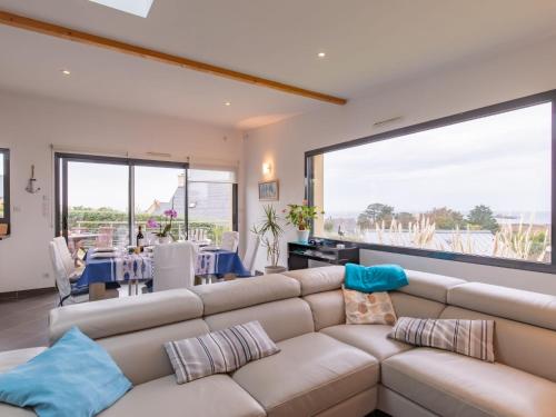 un salon avec un canapé et une grande fenêtre dans l'établissement Holiday Home Maison de Plain Pied - Vue Mer by Interhome, à Kergador