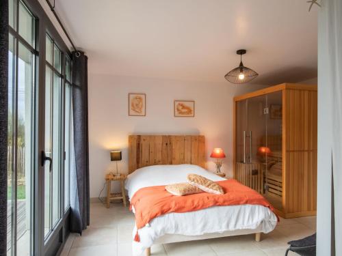 - une chambre avec un lit et une couverture orange dans l'établissement Holiday Home Le Petit Bonheur by Interhome, à Brignogan-Plage